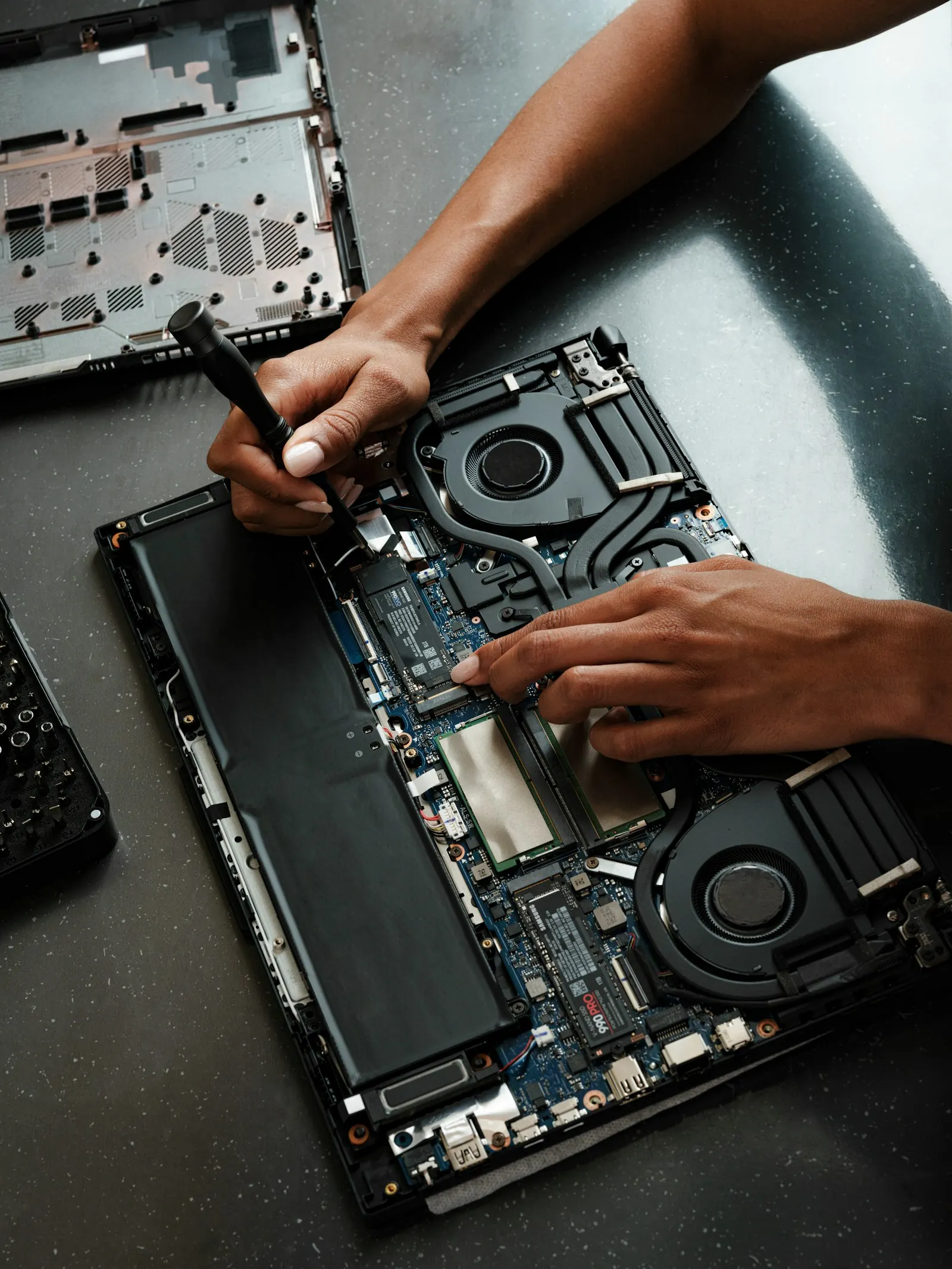 Tecnico che apre un notebook con un cacciavite per una riparazione
